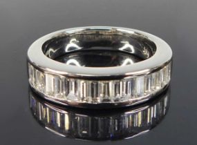 A platinum diamond half eternity ring, comprising 16 baguette cut diamonds in channel settings,