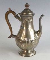 A late Victorian silver coffee pot, of part gadrooned baluster form upon a spreading circular