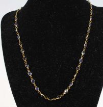 A contemporary yellow metal and blue sapphire necklace comprising 42 bezel set slightly graduated