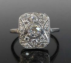 A white metal Art Deco diamond panel ring featuring a centre old European cut diamond in a bezel