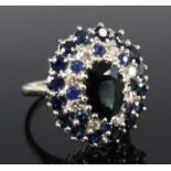 An 18ct white gold, sapphire and diamond oval cluster ring, featuring a centre oval sapphire