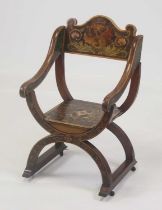 A late 19th century Arts & Crafts fruitwood and penwork decorated X-frame chair, having a panelled