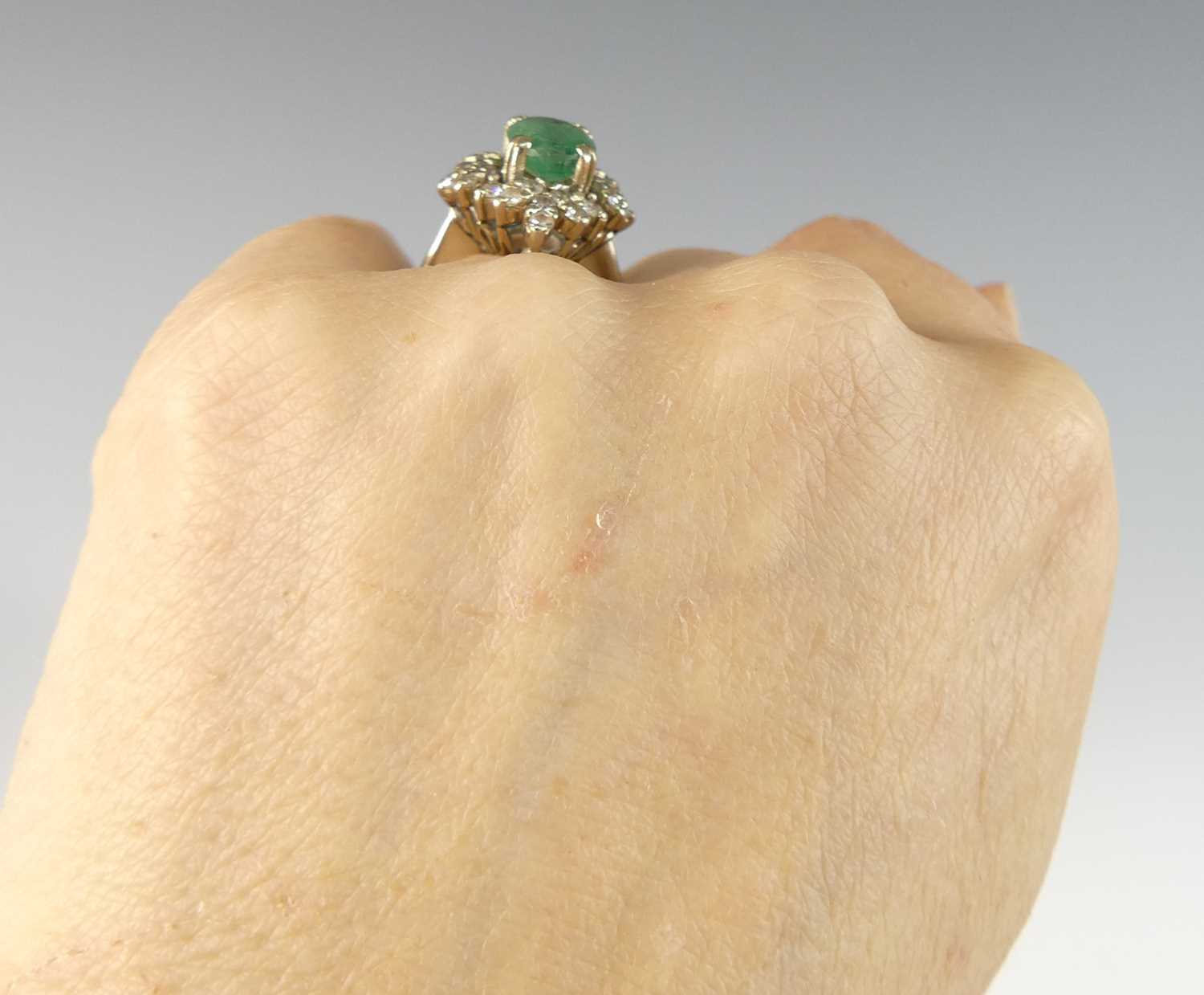 A white metal, emerald and diamond oval cluster ring, comprising a centre oval emerald within a - Image 7 of 7