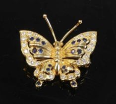 A yellow metal sapphire and diamond butterfly brooch comprising 18 round sapphires and 24 round