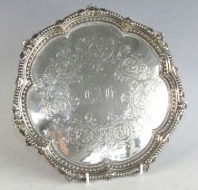 A late Victorian silver salver, of shaped circular form, having a scalloped raised rim ornately