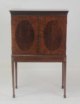 A 19th century mahogany fitted cabinet on stand, the twin oval panelled doors opening to reveal a