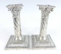 A pair of late Victorian silver plated table candlesticks, each of Corinthian column form with