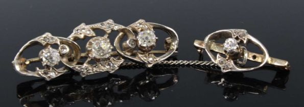 Two yellow and white metal diamond bar brooches, the larger featuring three graduated old cushion