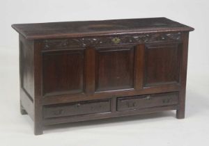 A circa 1700 oak mule chest, having a two-plank top on replacement iron strap hinges, above a carved