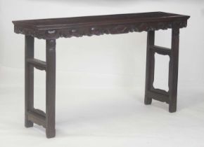 An early 20th century Chinese rosewood altar table, having a carved frieze and raised on square