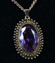 A contemporary synthetic colour change sapphire and yellow metal pendant, the oval cut amethyst