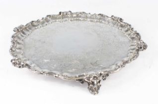 A Victorian silver salver, of shaped circular form with a floral scrolling raised rim, the ground