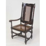 A Caroleon period walnut framed and split cane upholstered elbow chair, having flower head carved