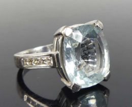 An 18ct white gold, aquamarine and diamond dress ring, comprising an oblong aquamarine in a four