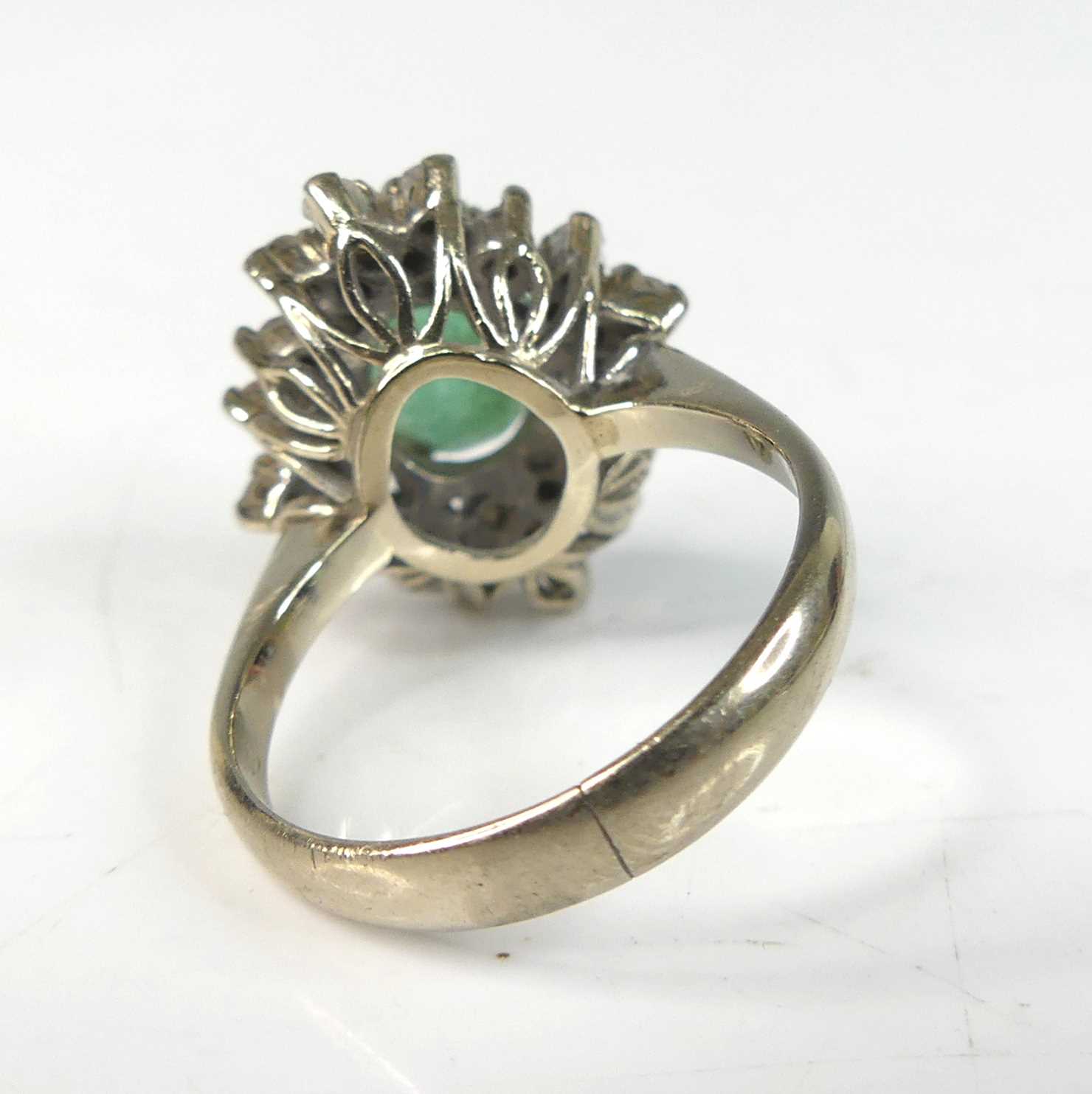 A white metal, emerald and diamond oval cluster ring, comprising a centre oval emerald within a - Image 3 of 7