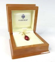 An 18ct yellow gold Fabergé egg pendant, with red guilloche enamel detail and foliate inlay,