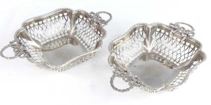 A pair of George V silver twin handled sweetmeat baskets, each of quatrafoil form with pierced