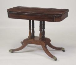 A Regency mahogany pedestal card table, having a fold-over top with canted corners, swivel action