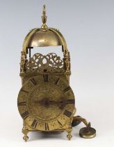 A circa 1700 brass lantern clock, the leaf and flower engraved dial below pierced dolphin frets