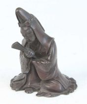 A Chinese bronze scroll weight, cast as a robed figure with fan in right hand, late Ming-Qing