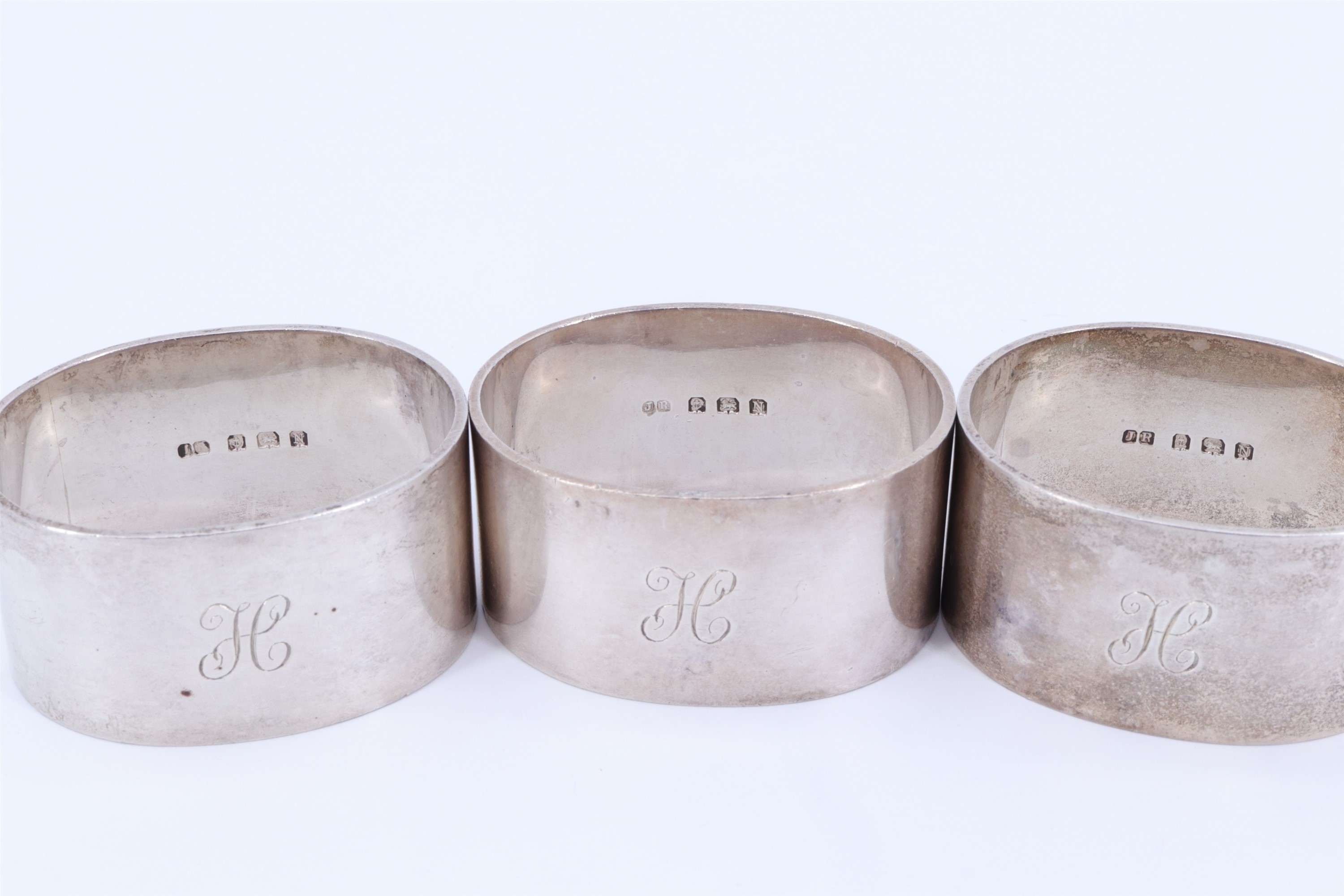 A trio of 1930s heavy silver napkin rings, of oval section and bearing the engraved initial H, - Image 2 of 3