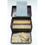 A vintage bamboo mahjong set, including its instruction booklet and a set of hand made bone dice