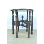 An early 20th Century Middle Eastern brass topped mother of pearl inlaid and carved folding table,