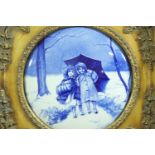 A reproduction convex Delft plaque, depicting a romantic winter scene with two children in the snow,