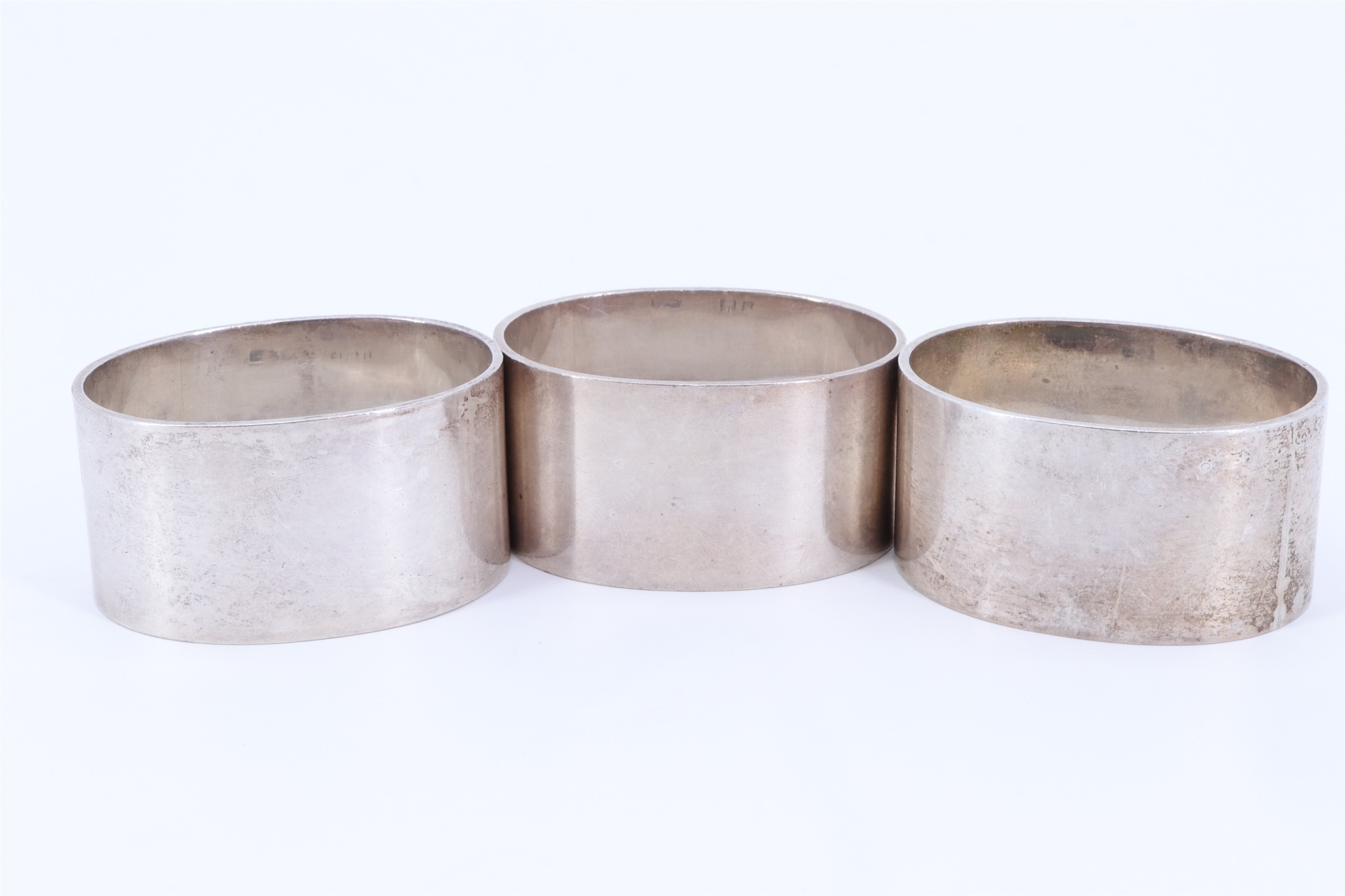 A trio of 1930s heavy silver napkin rings, of oval section and bearing the engraved initial H, - Image 3 of 3
