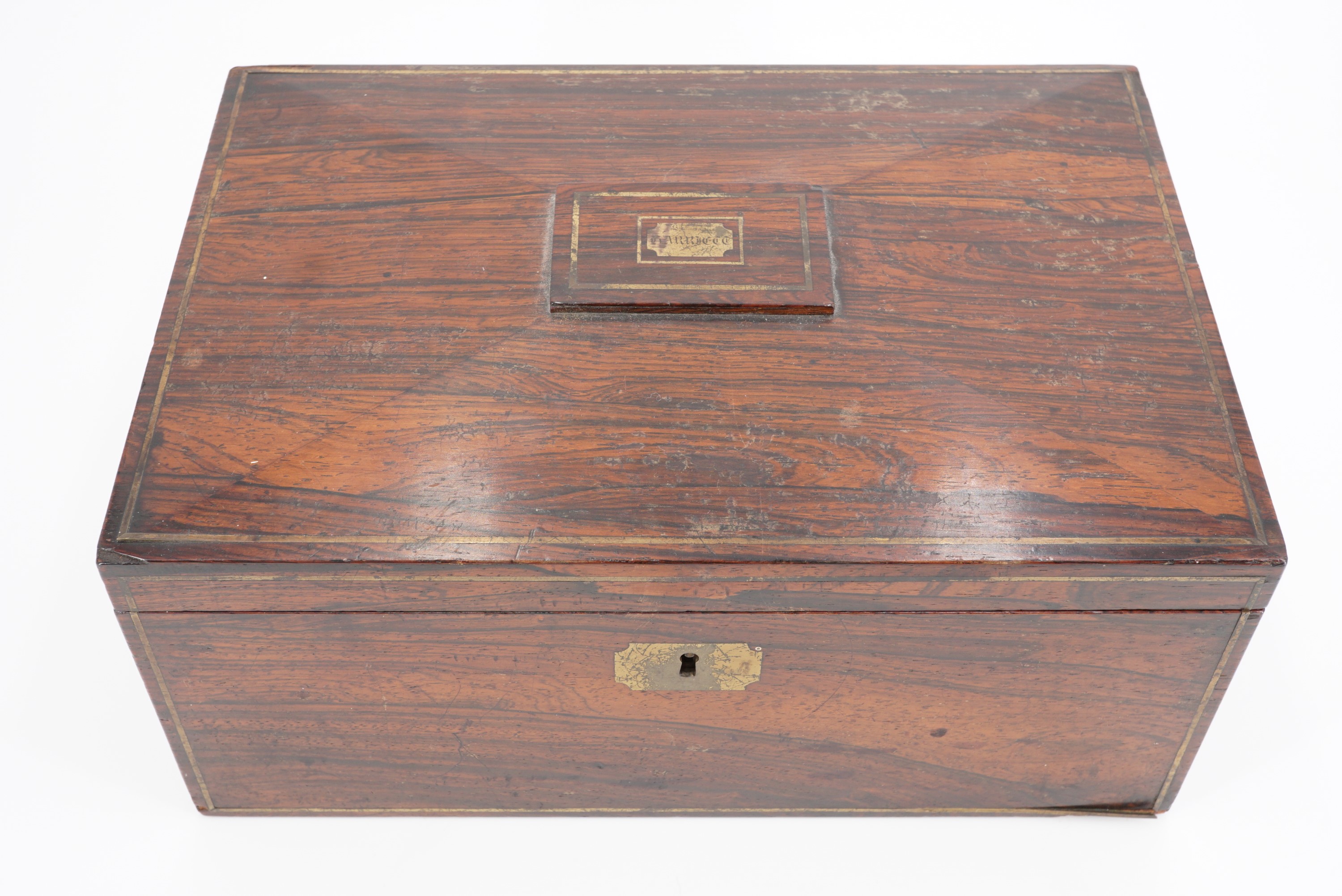 An early 19th Century rosewood veneered sewing workbox, having brass stringing and the top bearing a