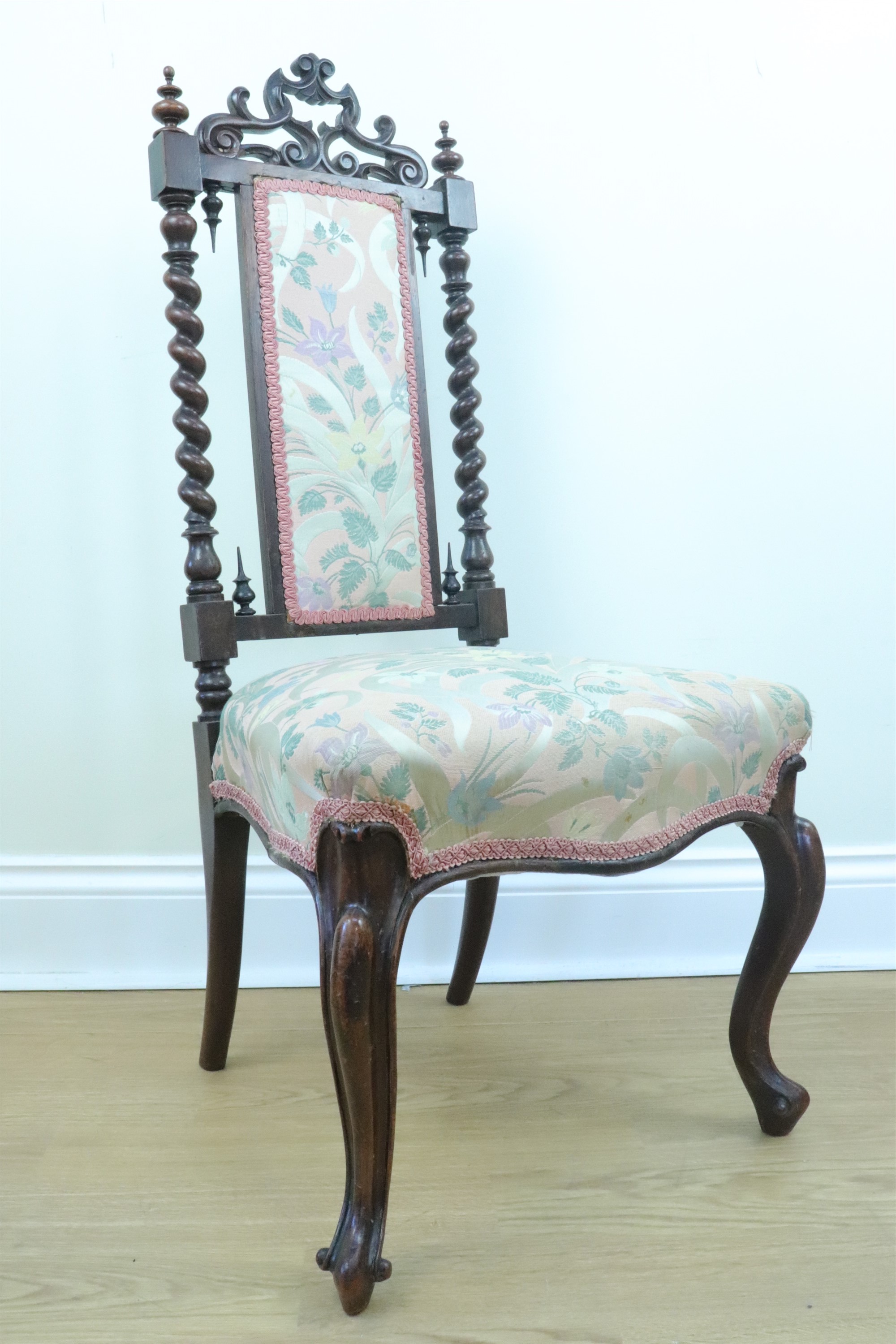 An Victorian carved walnut nursing chair with an adorsed barley twist back crested by a pierced