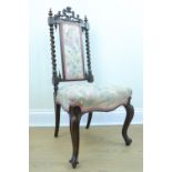 An Victorian carved walnut nursing chair with an adorsed barley twist back crested by a pierced