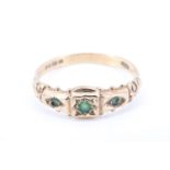 An ornate emerald set 9 ct gold ring, the head of the ring being a square between two trapezoids,