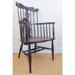 A 1930s carved oak comb back Windsor arm chair, 106 cm high