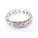 A 1960s 9 ct gold eternity ring, set with 17 chrysoberyl brilliants in a central white metal band on