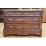 A German late 19th / early 20th Century carved walnut chest of three drawers, the