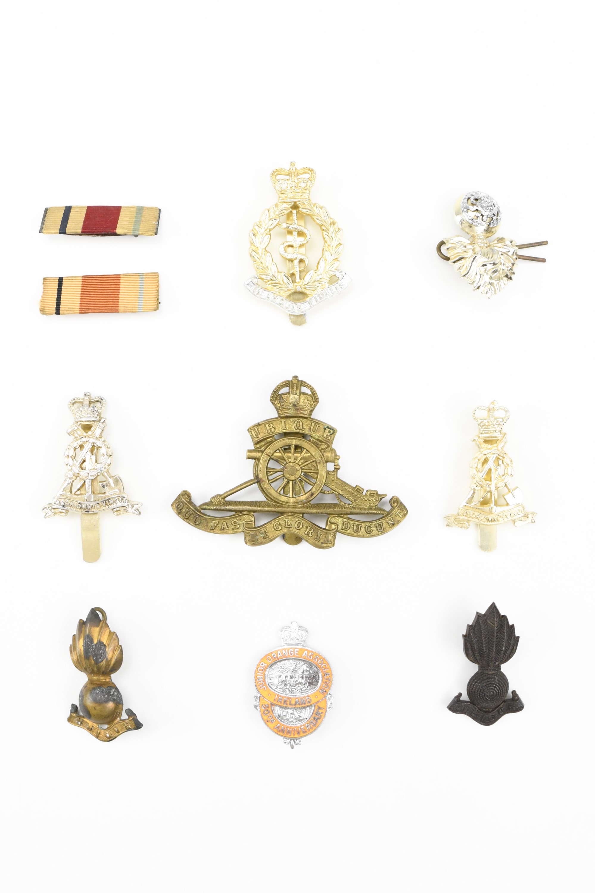 A small group of military insignia and medal ribbons including Staybrite cap badges