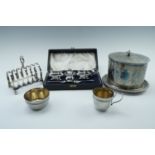 An Edwardian oval bodied biscuit barrel, a cased Walker and Hall electroplated condiment set, a