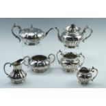 Two Victorian electroplated Britania metal three piece tea sets, being of compressed melon form, and