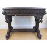 A late 19th / early 20th Century Flemish style heavily carved oak writing table, decorated overall