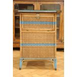 A 1930s cane bathroom / laundry cabinet by Belvoir, having a glass top held with brass mounts, the