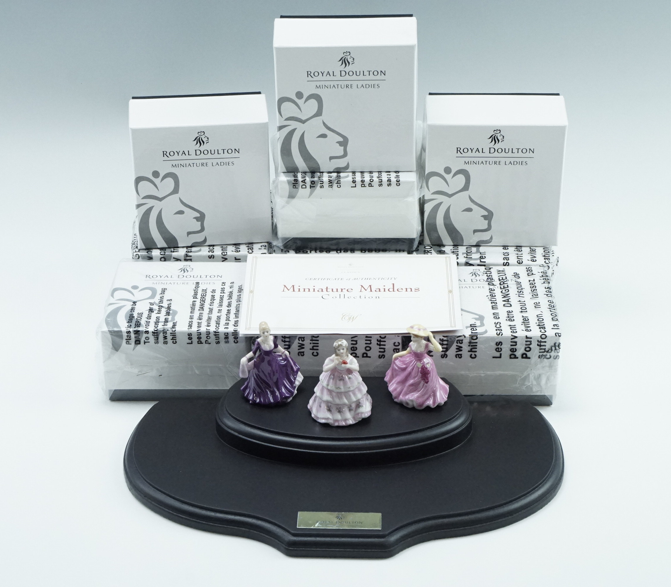 Ten boxed Royal Doulton figurines from the Miniature Maidens Collection, including a stand,