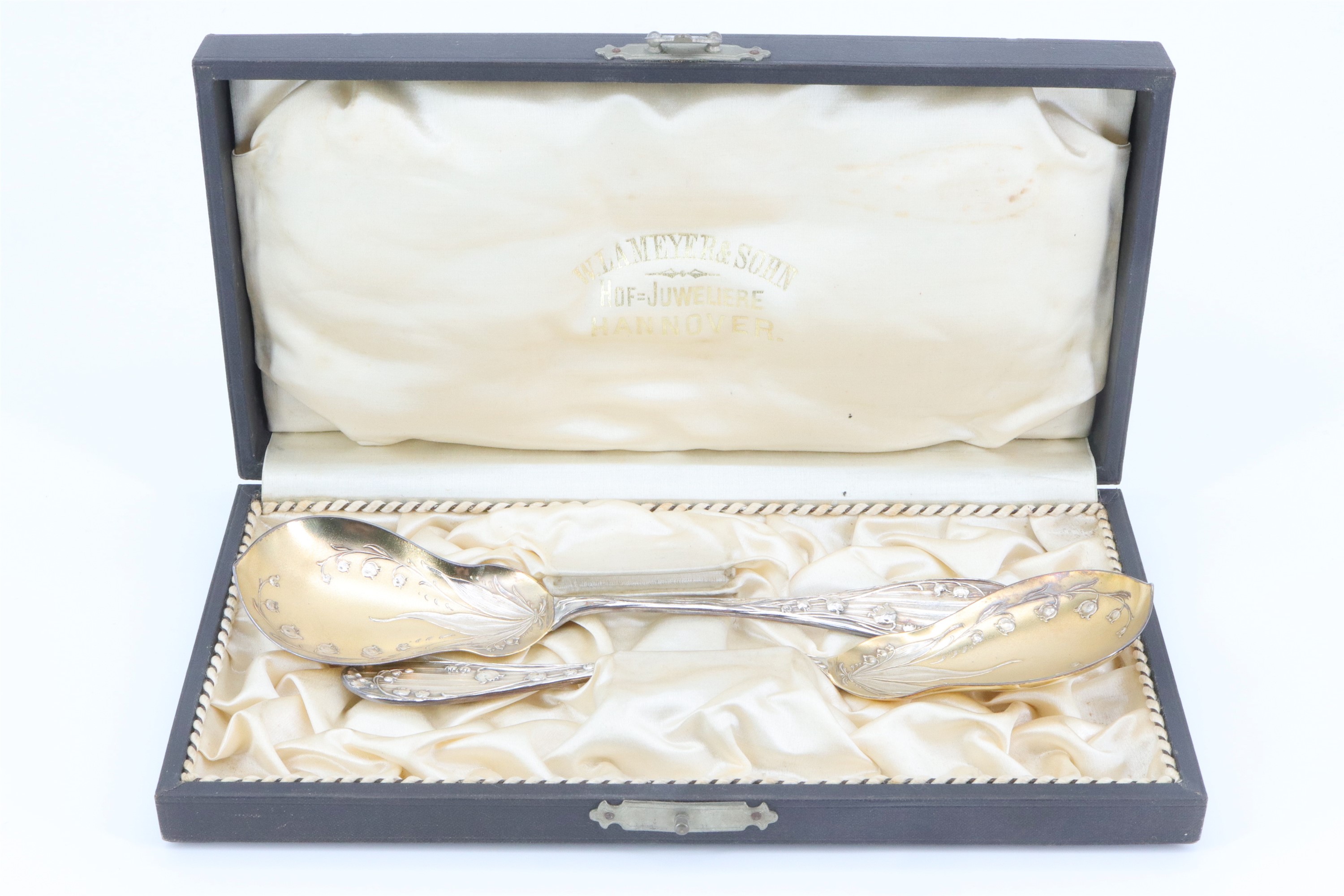 A cased pair of Belle Epoque German silver serving spoons, having pear shaped bowls, decorated