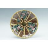 A 19th Century majolica plate, having wicker and cherry blossom decoration, (small crack to one