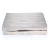 A 1920s silver table cigarette box, its subtly domed lid decorated with banded engine turning, 15 cm