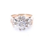 A 1970s diamond and 9 ct gold daisy ring, having an illusion set brilliant diamond, surrounded by