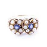 An early 20th Century pearl and sapphire ring, having two overlapping hearts, each centrally set