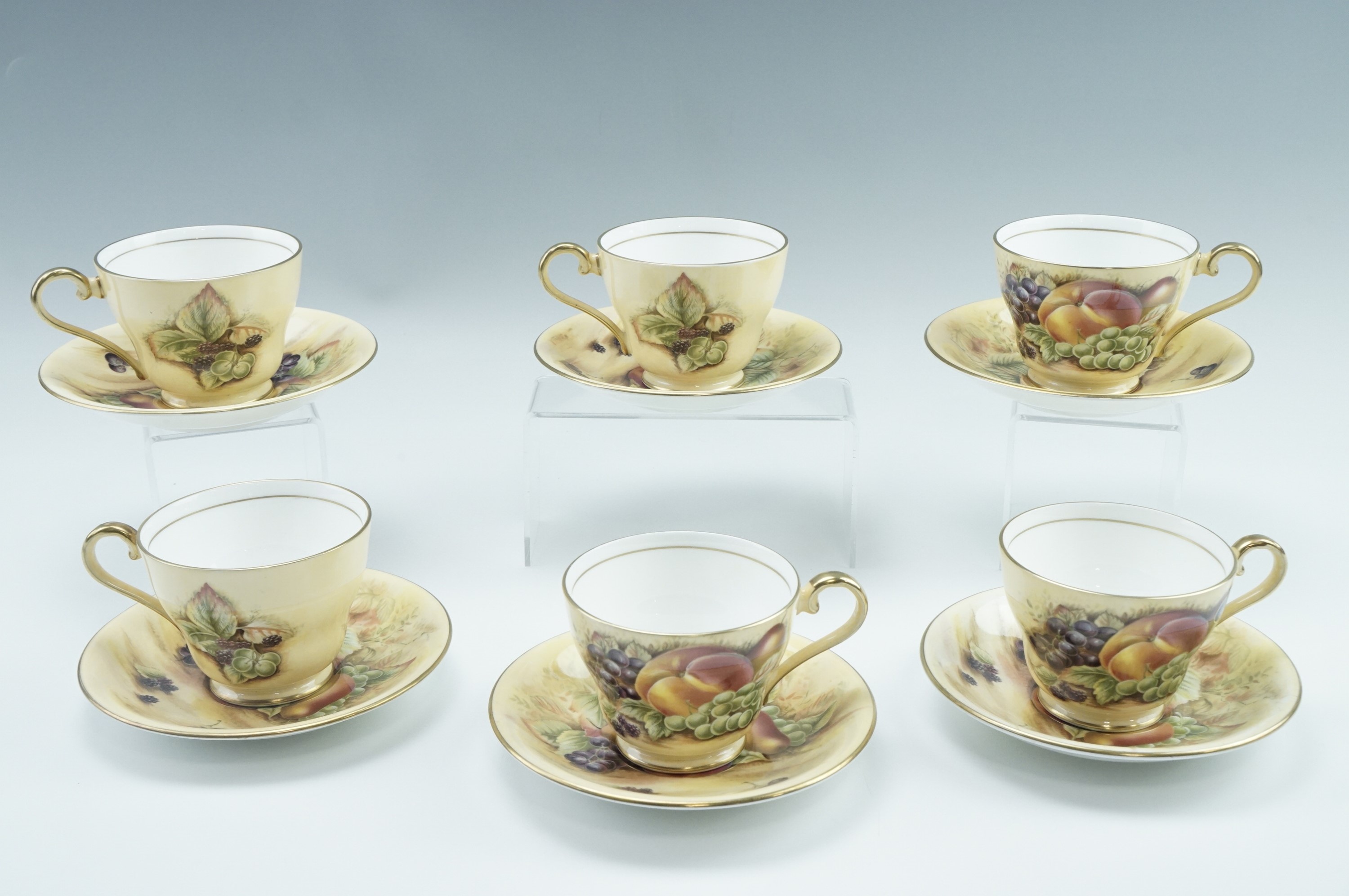 Six Aynsley Orchard Gold teacups and saucers, transfer decorated with fruit, late 20th Century, cups