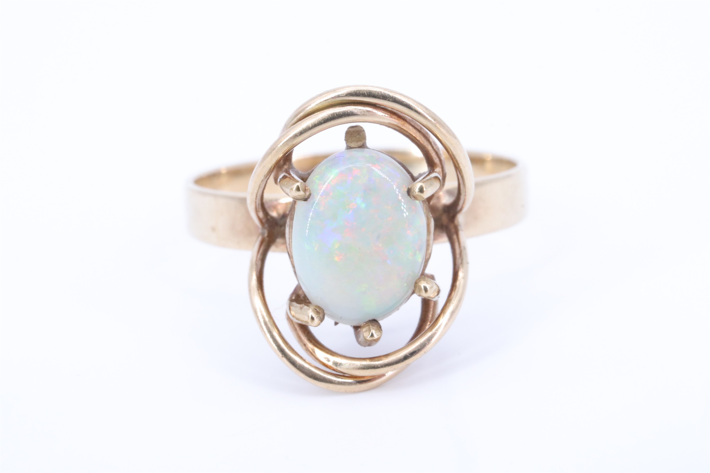 A George VI opal and 9 ct yellow metal ring, the oval opal cabochon transverse set on a crown