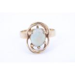 A George VI opal and 9 ct yellow metal ring, the oval opal cabochon transverse set on a crown